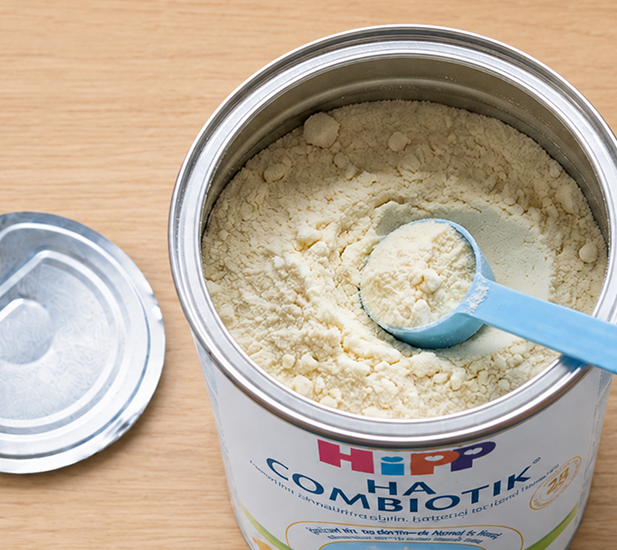 Open tin of HiPP HA Combiotik formula with a scoop