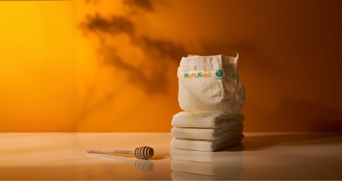 Manukind premium diapers stacked on a wooden surface